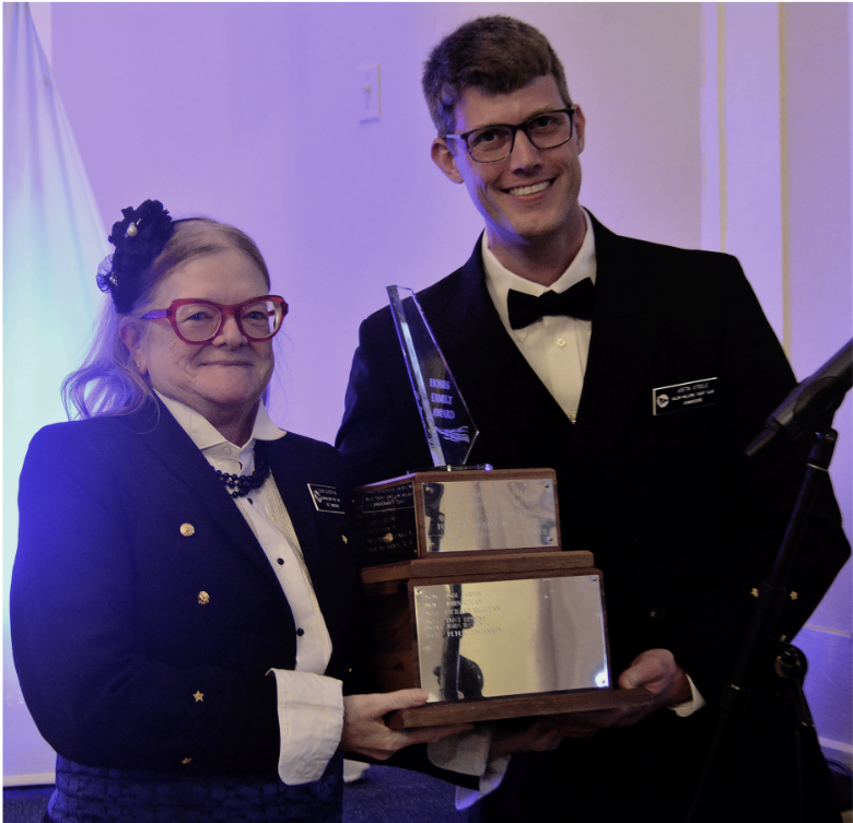 Commodore Justin Steele presents the Hobbs Award to Elvira Schoenthal (April 2026).